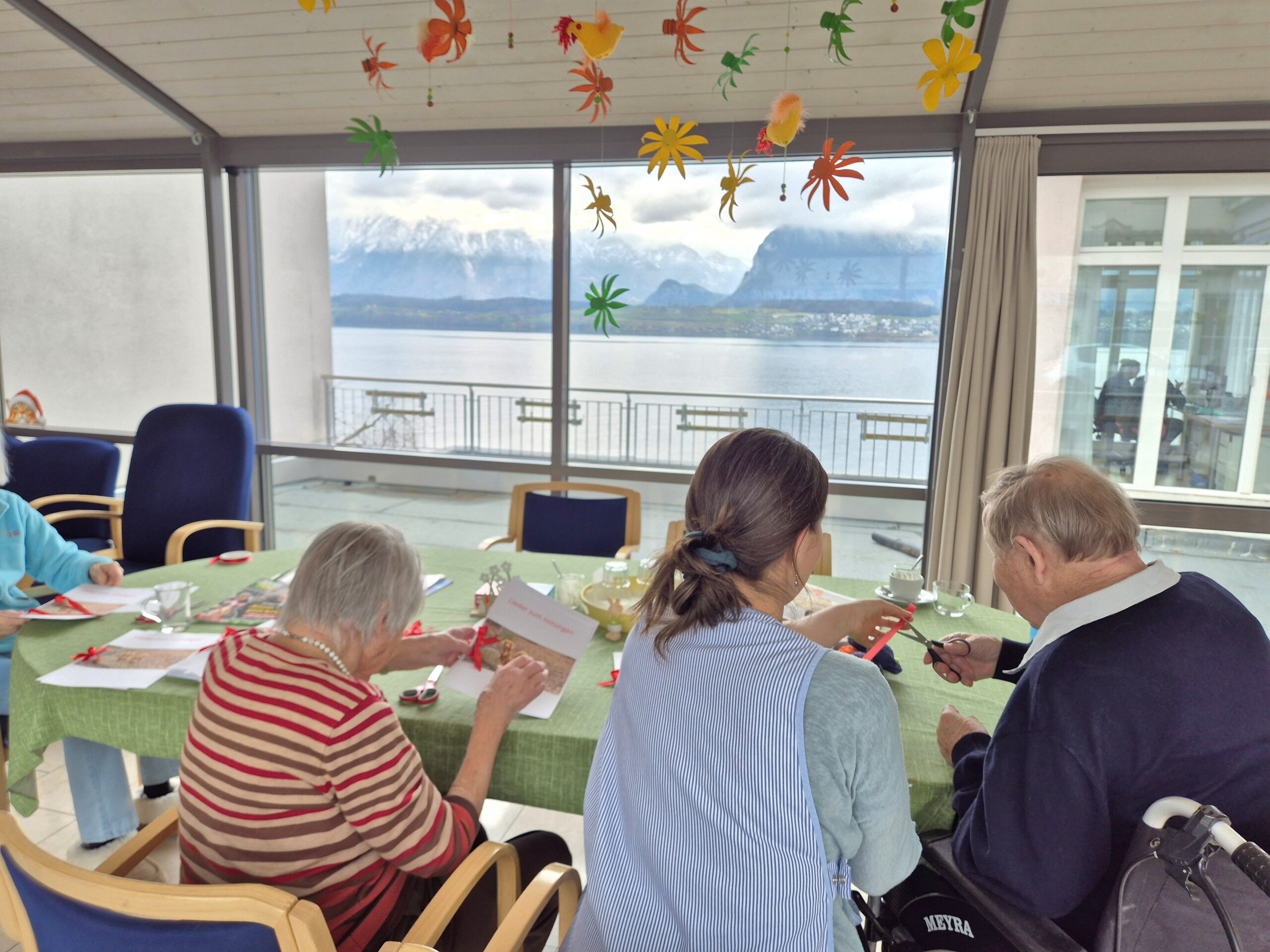 Bewohnende und Mitarbeiterin beim Basteln in der Aktivierung